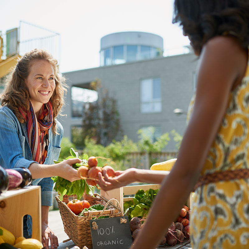 Friendly woman selling fresh vegetables from the rooftop garden.