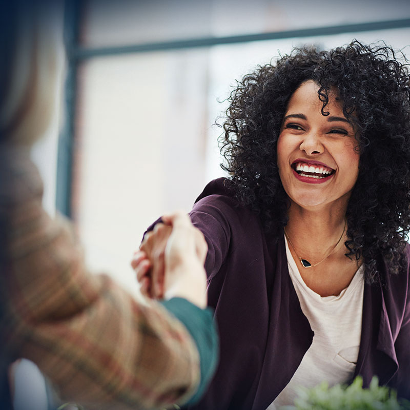 Handshake with a happy, confident and excited business woman and a female colleague.